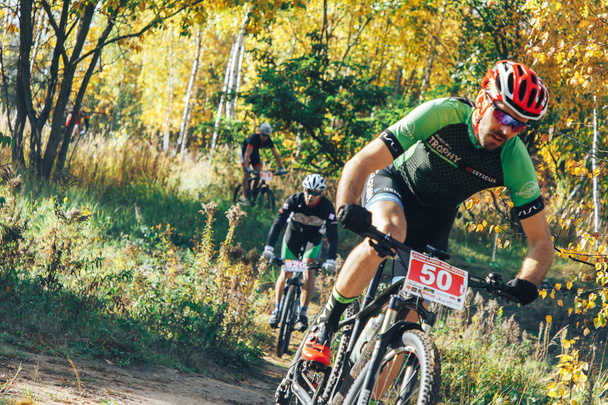 October, 14, 2018 - Minsk, Belarus: 2018 Olympic Cross Country Cup XCO in Medvezhino, men riding bicycles along forest trail - Foto, imagen