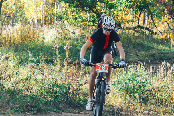 October 14, 2018, Minsk, Belarus: 2018 Olympic Cross Country Cup XCO in Medvezhino, man riding bicycle in park - Foto, afbeelding