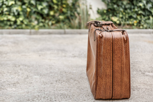 Old vintage suitcase of brown color located on the right side of the photograph - Photo, image