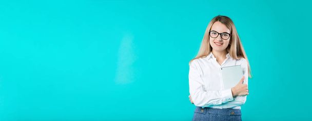 Portré fiatal kaukázusi nő munkavállaló tanári oktatói mentori fehér ing office stílusú hosszú haj tabletta a kezében használ technológia elszigetelt világos kék szín háttér. - Fotó, kép
