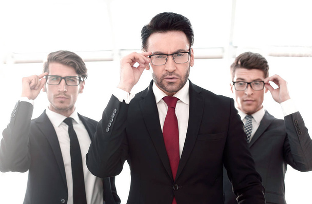 три бізнесмени в окулярах, вигадливо дивлячись на камеру
 - Фото, зображення