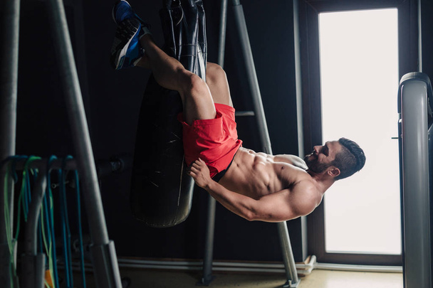 Strong man in the gym doing abs exercise - Fotoğraf, Görsel