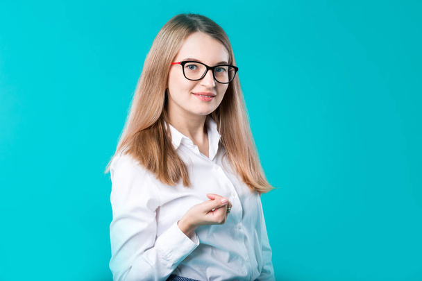 Blank for advertising. Portrait young caucasian woman worker teacher coach mentor in white shirt office style business lady leader advertising glasses eyesight blue isolated color background. - Fotografie, Obrázek