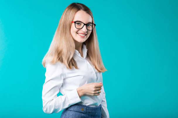 Blank for advertising. Portrait young caucasian woman worker teacher coach mentor in white shirt office style business lady leader advertising glasses eyesight blue isolated color background. - Foto, afbeelding