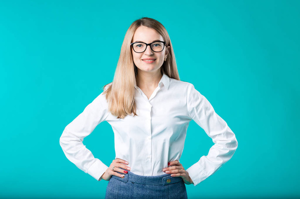 Blank for advertising. Portrait young caucasian woman worker teacher coach mentor in white shirt office style business lady leader advertising glasses eyesight blue isolated color background. - Fotografie, Obrázek