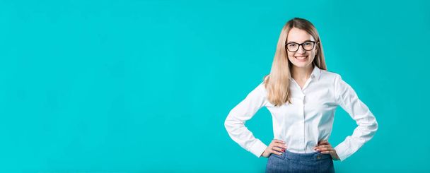 Blank for advertising. Portrait young caucasian woman worker teacher coach mentor in white shirt office style business lady leader advertising glasses eyesight blue isolated color background. - Zdjęcie, obraz