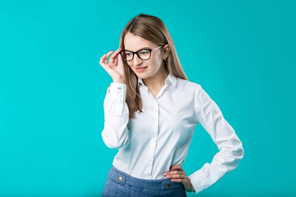 Blank for advertising. Portrait young caucasian woman worker teacher coach mentor in white shirt office style business lady leader advertising glasses eyesight blue isolated color background. - Foto, afbeelding