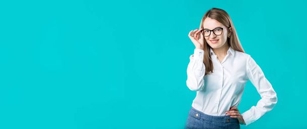 Blank for advertising. Portrait young caucasian woman worker teacher coach mentor in white shirt office style business lady leader advertising glasses eyesight blue isolated color background. - Photo, Image