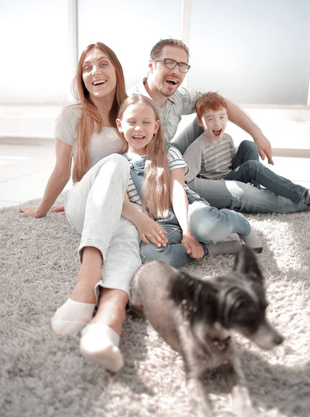 cheerful family sitting on the floor in the living room - Fotoğraf, Görsel
