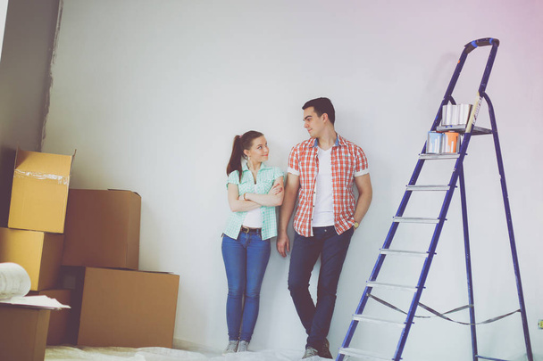 Portrait of young couple moving in new home. Young couple - Фото, изображение