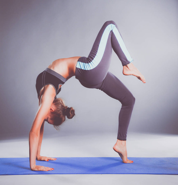 Portrait of sport girl doing yoga stretching exercise - Фото, изображение