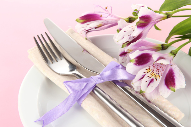 Festive dining table setting with flowers on pink background - Valokuva, kuva