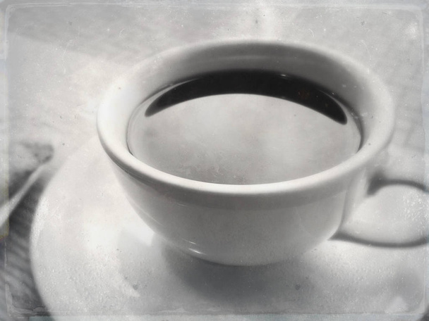 Czarna kawa w biały ceramicznych filiżanka i spodek w kawiarni w naturalnym świetle. - Zdjęcie, obraz