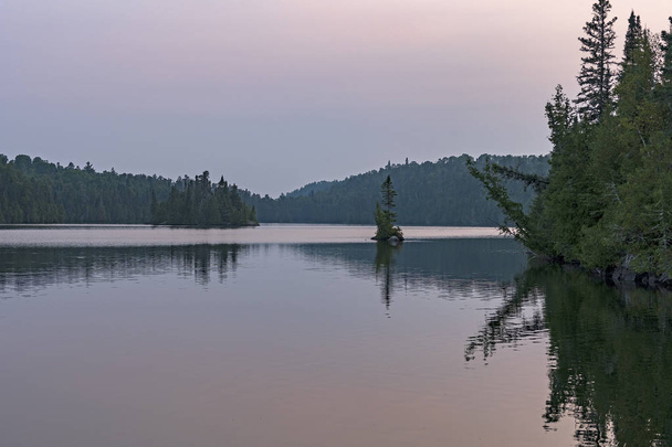 Acque calme al crepuscolo nel bosco del nord sull'altro lago Man nel parco provinciale di Quetico in Ontario
 - Foto, immagini