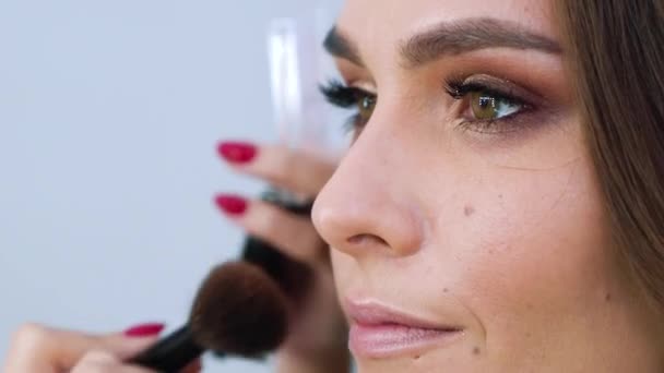 closeup of young woman getting professional makeup - Video, Çekim