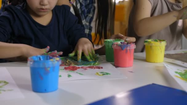 Multi ethnic little girls finger painting at class - Footage, Video