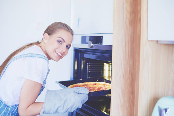 Happy young woman cooking pizza at home - Foto, Imagem