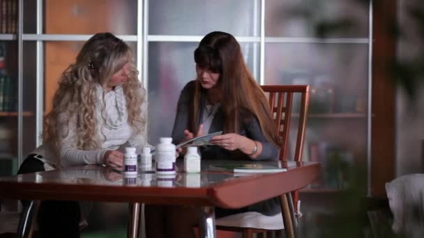 Frau zeigt einer anderen Frau die Pillen - Filmmaterial, Video