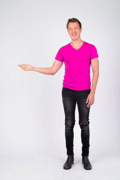 Full body shot of happy young handsome man showing something - Photo, Image