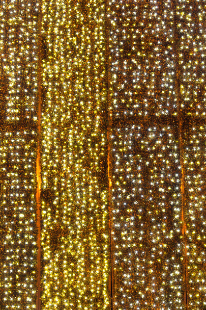 Funkelnde Weihnachtsbeleuchtung Hintergrund. Wand von Weihnachtsbeleuchtung erleuchtet - Foto, Bild