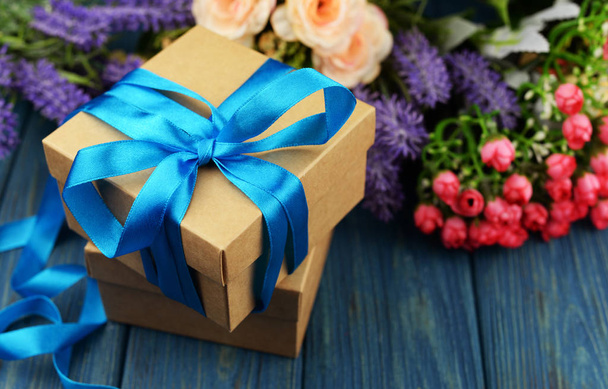 έκπληξη δώρο κουτί με μπλε το καλοκαίρι με ένα μπουκέτο τριαντάφυλλα και λεβάντα σε μπλε φόντο ξύλινη για την ημέρα του Αγίου Βαλεντίνου διακοπές και το νέο έτος Χριστούγεννα - Φωτογραφία, εικόνα