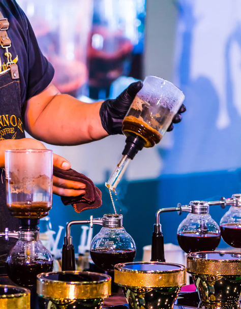 Syphon Coffee o Vacuum Coffee è full immersion di buon gusto, questa immagine mostra mescolare i chicchi di caffè in acqua bollente e mescolare 10 volte
. - Foto, immagini