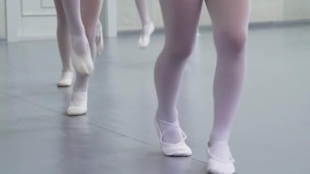 Vértes lábak kis ballerinas csoport fehér cipő gyakorló balett stúdióban, lassú mozgás. Fiatal lányok, a képzési elemek, a klasszikus tánc gyakorlása. Gyermekkori, tánc, életmód fogalma - Felvétel, videó