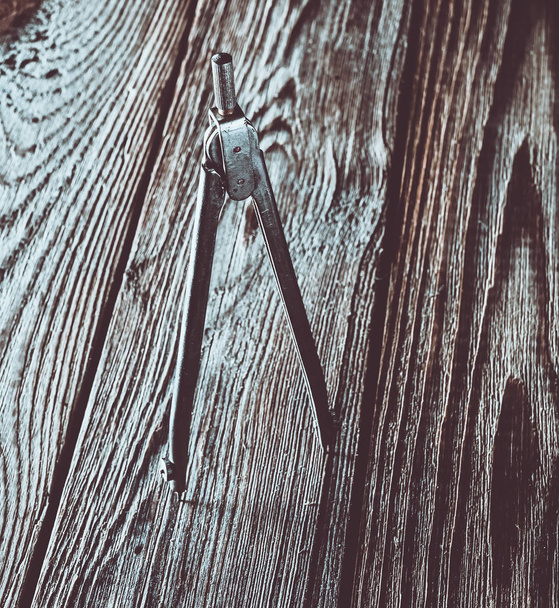 Metal compasses on a wooden table. - Foto, Imagem