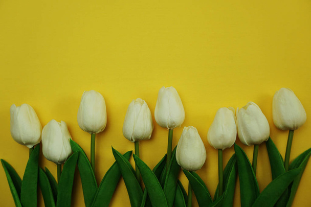 white tulip flower bouquet with space copy on yellow background - Fotó, kép