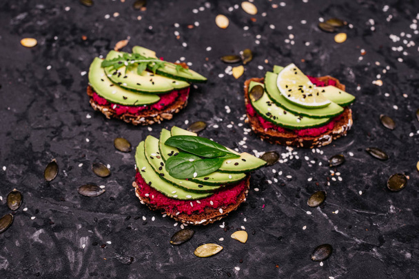 Food, avocado, healthy food. Avocado sandwiches with seeds, sesame and a lime. It can be used as a background - Photo, image