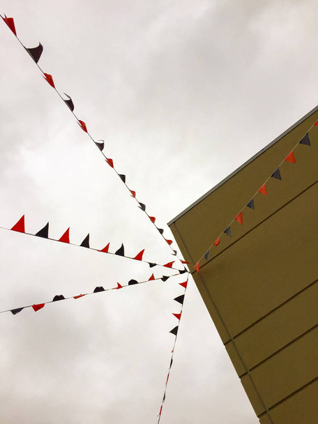 Прапори у формі трикутника, прикріплені до будівлі
. - Фото, зображення