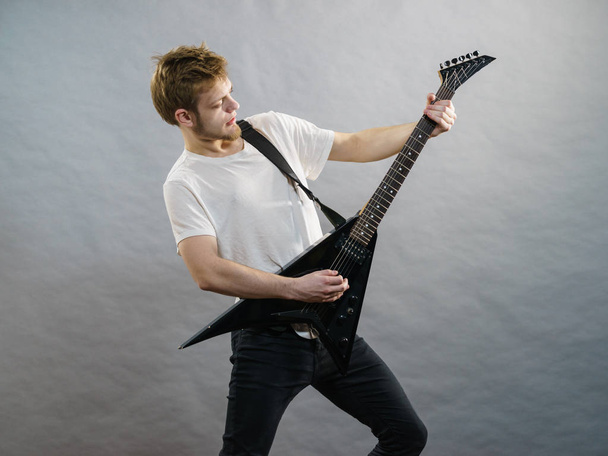 Man being passionate about his music hobby, playing electric guitar emotionally. - 写真・画像
