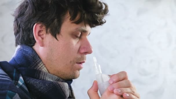 Sick man inhaling through inhaler nozzle for nose. Close-up face, side view. Use nebulizer and inhaler for the treatment. - Video