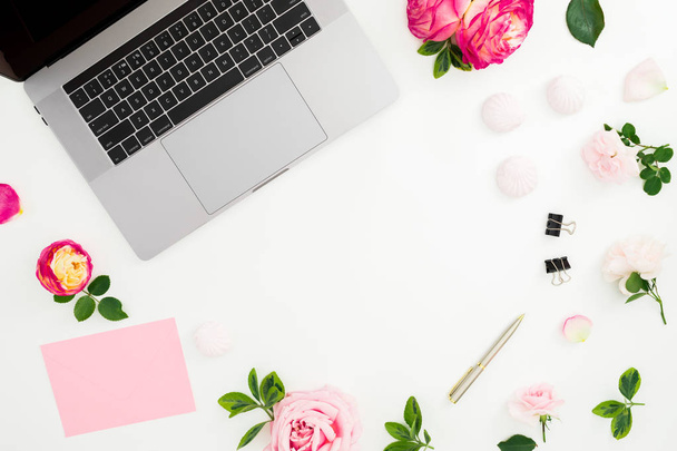 Laptop, flores de rosas, diário, caneta, envelope e marshmallow no fundo branco. Deitado. Vista superior. Composição feminina com lugar de cópia
 - Foto, Imagem
