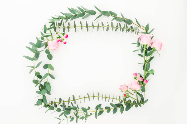 Floral wreath frame of pink roses and eucalyptus branches on white background. Flat lay, top view - Foto, Bild