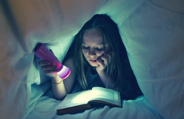 Молода дівчина читає книгу в ліжку
 - Фото, зображення