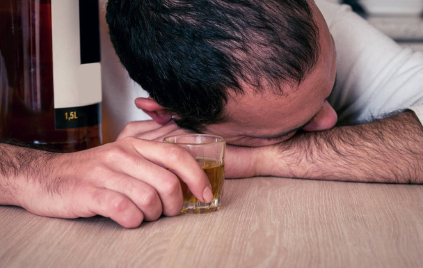 Alkoholijuoma ja humalainen mies keittiössä
 - Valokuva, kuva