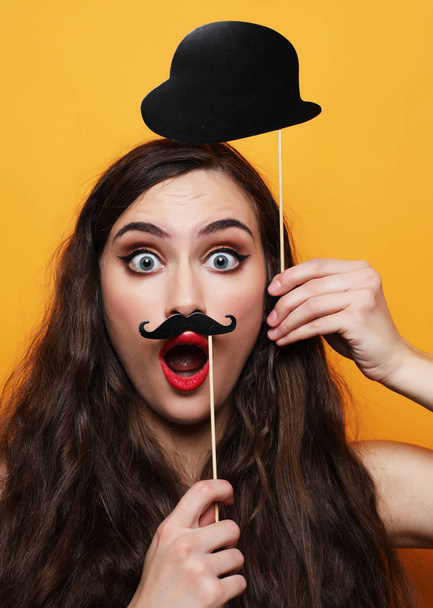  playful young woman ready for party over yellow background - Foto, immagini