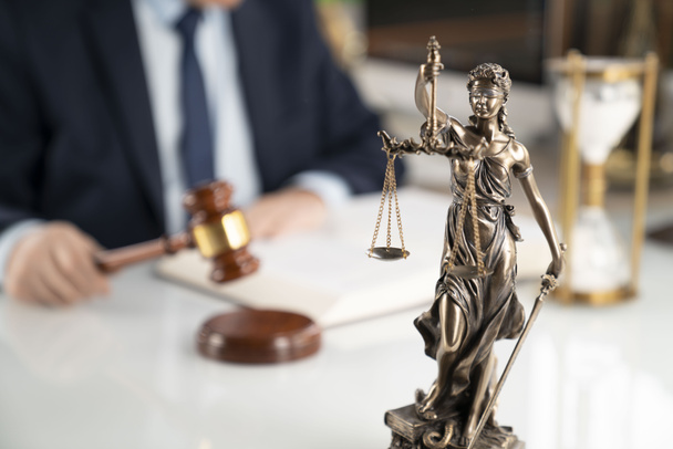 Hintergrund des Anwaltskonzepts. Rechtsanwältin im Büro. Gabel, Themis-Statue und Rechtsbuch auf dem weißen Glastisch. - Foto, Bild