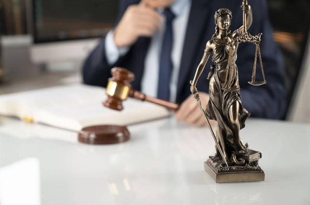 Hintergrund des Anwaltskonzepts. Rechtsanwältin im Büro. Gabel, Themis-Statue und Rechtsbuch auf dem weißen Glastisch. - Foto, Bild