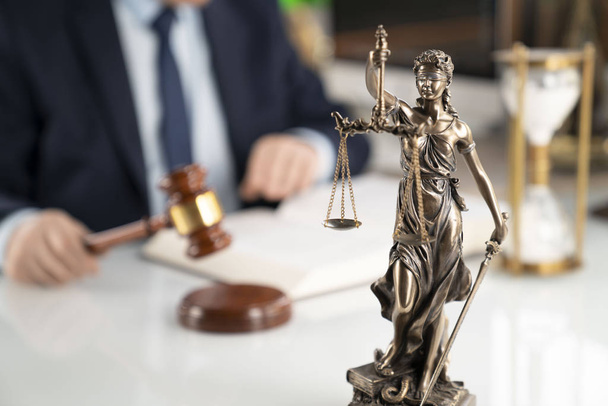 Lawyer concept background. Lawyer working at the office. Gavel, Themis statue and legal book on the white glass table. - Photo, Image