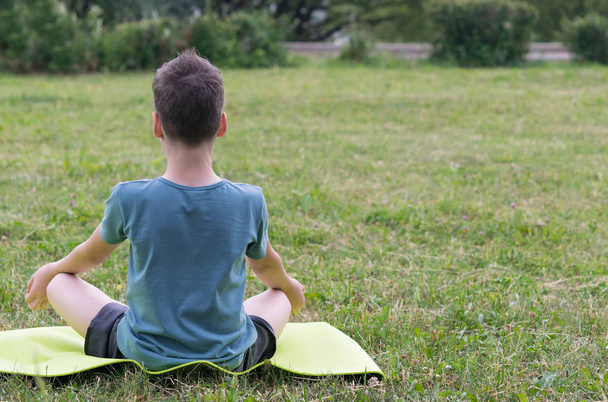 boy doing yoga outdoors in the park - Foto, Bild