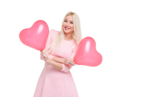 Beautiful young blond woman with pink heart shape air balloon on white isolated background. Woman on Valentine's Day. Symbol of love - Image - Foto, Imagem