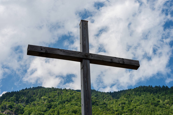 Wooden cross in mountain, Italian Alps, with a blue sky and clouds. Religious symbol - Photo, Image