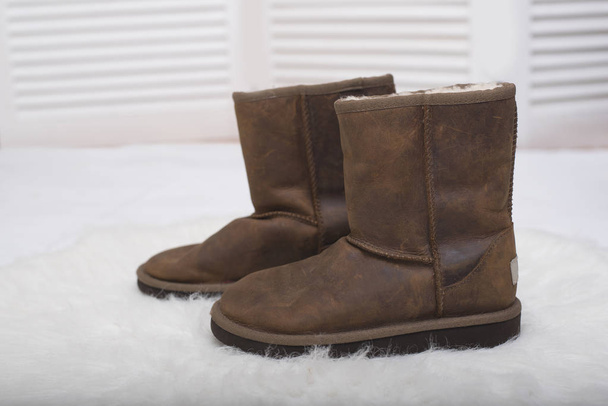 Winter brown boots on white fur. Fashion concept - Photo, Image