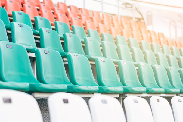 weiße, rote und mintfarbene Kunststoffsitze, reihenweise in einem Stadion angeordnet. gesunder Lebensstil, weicher Fokus - Foto, Bild