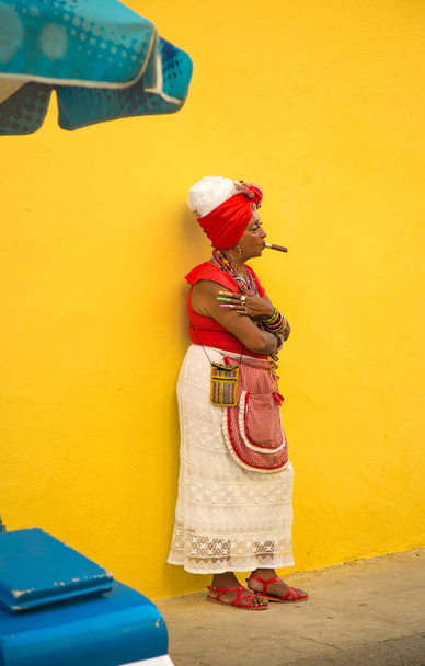 HAVANA-CUBA- DEC 4, 2018:  Cuban cigar smoking woman agains a yellow wall - Фото, зображення