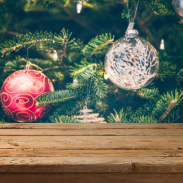 Christmas background with empty wooden table over Christmas tree decorations. - Photo, Image