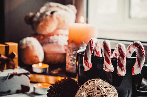 Juguete suave y velas sobre fondo de madera con decoraciones navideñas - Foto, Imagen