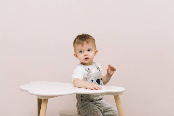 Cute baby sitting at the table in the form of a cloud in the nursery bright colors. - Fotografie, Obrázek